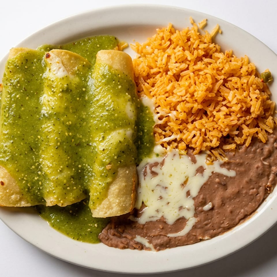 Plate of enchiladas covered in green salsa with Mexican rice and refried beans topped with melted cheese.