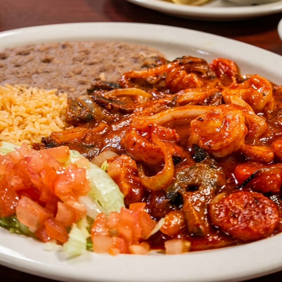 Plate of shrimp, grilled vegetables, sausage, Mexican rice, refried beans, and salad with salsa on the side.